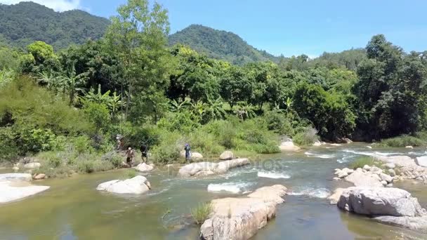 2017年8月26日 空中景观的家伙与电动钓鱼竿跳过激流石在美丽的河上反对棕榈和香蕉树在8月26日在芽庄 — 图库视频影像
