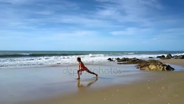 Slanke Vrouw Rode Zwembroek Bezit Yoga Positie Virabhadrasana Kust Tegen — Stockvideo