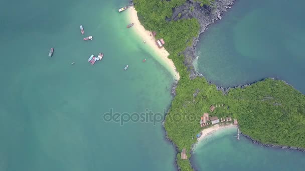 无人机在宁静蔚蓝海湾的热带森林沙滩和建筑物上空旋转 高高的在岩石岛上的奇形岛屿 — 图库视频影像