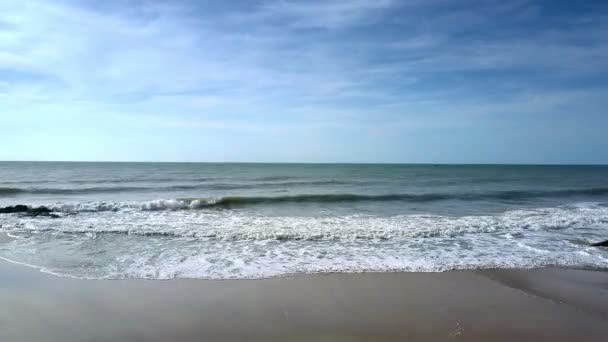软波浪卷在海滩到亭亭玉立的女孩在泳装做瑜伽位置 Virabhadrasana 在湿沙子对蔚蓝的海洋 — 图库视频影像