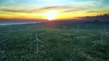 dönen Rüzgar türbinleri ve arka planda inanılmaz parlak günbatımı güzel üst görünüm Vadisi