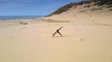 ince kız yoga pozlar masmavi berrak gökyüzü karşı çölde kum arasında değişen çevresinde hava panorama