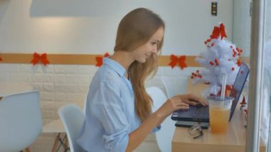 yan görünümü sarışın uzun saçlı kız bilgisayar gülümsüyor beyaz Noel ağacına web sitesinde arar