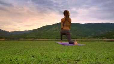tropikal highland resimsel gölde tarafından diz yoga poz dron yan görünümü çok ince kız uzun saçlı tutar