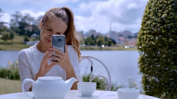 Vértes Gyönyörű Lány Vesz Tábla Fénykép Kávézóban Ülve Átrendezi Teáscsészét — Stock videók