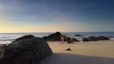 Harika panorama sabah ince sarışın kız yoga poz okyanus plaj deniz manzarası ve sahil resort karşı bilir