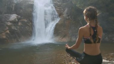 rock saatler köpüklü şelale arasında uçurumlar çalıştıran closeup arka panorama ince kız örgü ile oturur