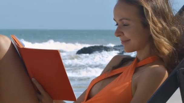 特写漂亮的女孩橙色泳装写下来的想法对图片海景日记梦想 — 图库视频影像
