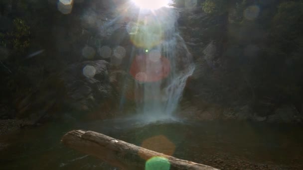 梦幻般的景观泡沫瀑布运行之间的峡谷岩石落入湖下闪闪发光的灼热的太阳射线 — 图库视频影像