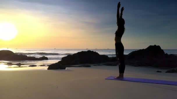 黒は太陽の明るい太陽と海の海岸でヨガを挨拶で空撮若い運動女性 — ストック動画