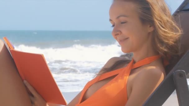 Bikini Szőke Hosszú Hajú Hölgy Kanapé Longue Könyv Ocean Beach — Stock videók