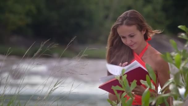 Viento Sacude Chica Largo Pelo Rubio Lee Libro Rojo Orilla — Vídeos de Stock