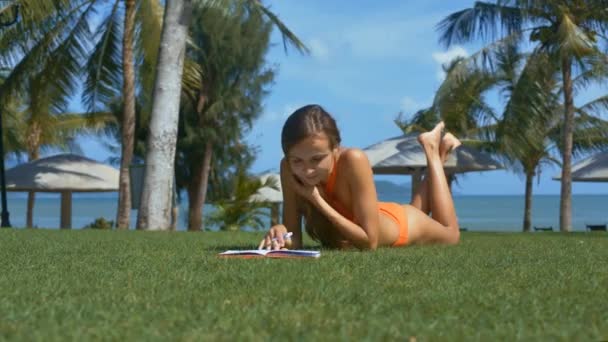 Bela Jovem Escreve Notebook Grama Fresca Parque Céu Claro Fundo — Vídeo de Stock