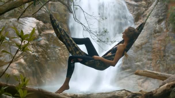 Menina Loira Top Preto Leggings Encontra Rede Macia Contra Cachoeira — Vídeo de Stock