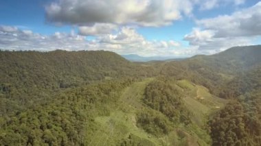 Mavi Gökyüzü bulutlu karşı tropikal orman ile yeşil tepelerin nefes kesen hava görünümünü yükü güç hatları çapraz