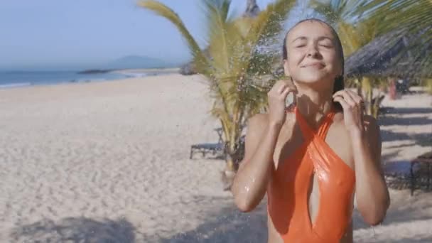 Ganska Långhårig Flicka Orange Bikini Skrattar Tar Färska Dusch Sandstrand — Stockvideo