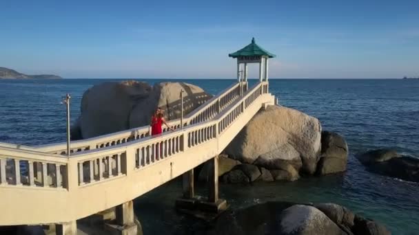 Prachtige Luchtfoto Meisje Heldere Rode Jurk Maakt Selfie Stenen Brug — Stockvideo