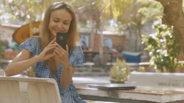 Mujer Rubia Sonriente Toma Fotos Teléfono Inteligente Mesa Piedra Con — Vídeos de Stock