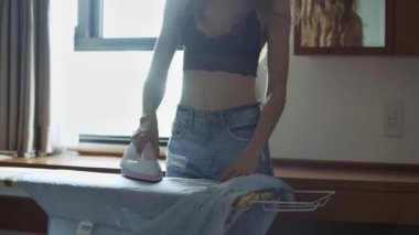 kot şort ve siyah üst ince kız giysileri ile beyaz ve pembe flatiron kontrol masasında ütüler