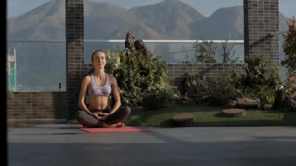 Nahaufnahme Mädchen Sitzt Yoga Position Padmasana Auf Dachterrasse Gegen Hügel — Stockvideo