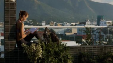 portre yan görünümü genç kız kitap etkileyici hills şehir yükselen karşı dinlenme terasta oturan okur