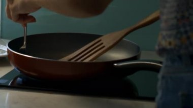 Yazlık elbise arka görünümü kız büyük tava soba, çatal ve raket ile lezzetli gözleme açar