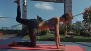 fitness egzersizleri yeşil Saksı bitkiler ile çatı terasında closeup güzel ince sarışın kız uzun örgüler ile uygulamaları