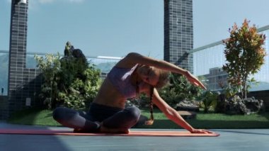 sarışın kız çatı kat mat sınırsız mavi gökyüzü altında city karşı oturup yoga poz düzeltmeleri Görünümü Kapat