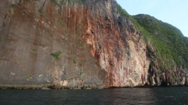 karanlık tropikal okyanusun üzerinde yükselen büyük kırmızı rock Panoraması