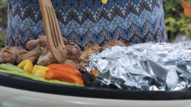 mavi ve gri elbiseli closeup kadın spatula ve Barbekü bıçakta lezzetli aromatik et parçaları döner