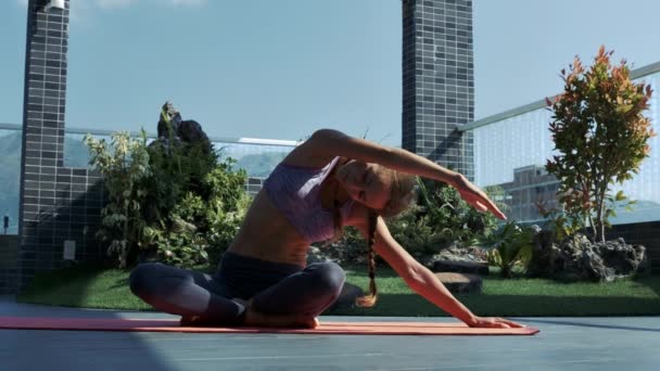 Stäng Visa Blond Flicka Fixar Yogaställning Som Sitter Taket Golvmatta — Stockvideo