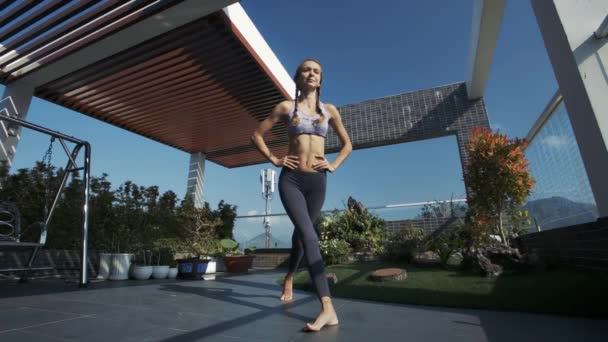 特写小女孩与辫子做运动蹲在装饰公寓屋顶交叉腿 — 图库视频影像
