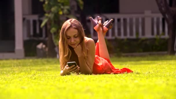 Nahaufnahme Hübsches Blondes Mädchen Liegt Auf Gras Und Chattet Mit — Stockvideo