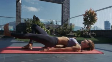 portre yan görünümü atletik kadın kaldırma leğen kemiği ve sol bacağı güzel lounge terasta spor
