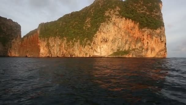 相机漂浮在岩石岛上 在海洋的喜悦中覆盖着冉冉升起的太阳的绿光 — 图库视频影像