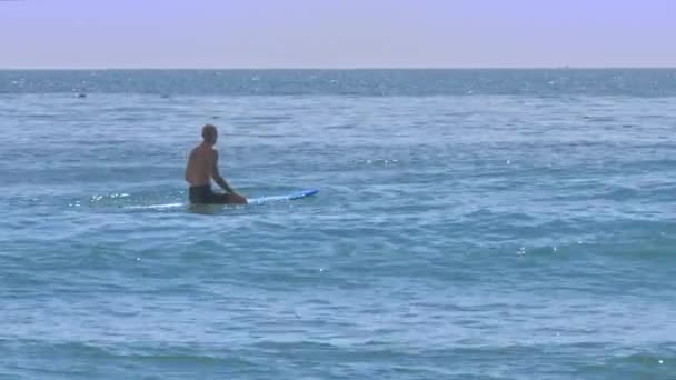 2018年3月15日 秃头的家伙坐在冲浪板上航行在和平的海洋在炎热的太阳照耀下在3月15日在芽庄 — 图库视频影像