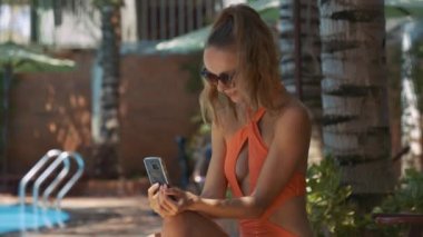 havuz evi tarafından karşı cep içine closeup oldukça uzun saçlı Bayan güzel turuncu bikini görünüyor