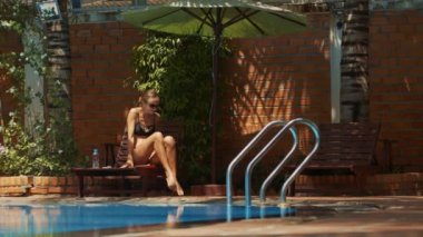 güzel siyah Bikini genç ince Bayan ayağa kalkar ve Yüzme Havuzu metal Merdiven Küpeşte ile gider