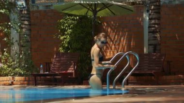 kırmızı tuğla havuz korkuluk karşı ev tutan su içine closeup yan görünüm gülümseyen kız güzel rakam ile düşüyor