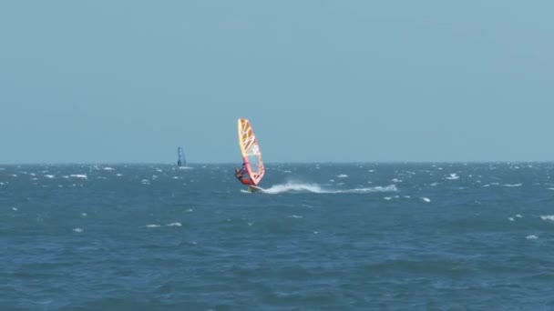 Mann Surft Auf Farbenfrohem Surfbrett Und Macht Spritzer Gegen Weit — Stockvideo