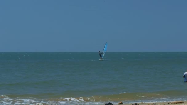 风帆风帆在蔚蓝的海洋和接近海滩以泡沫波浪在前景反对蓝色天空在地平线上 — 图库视频影像