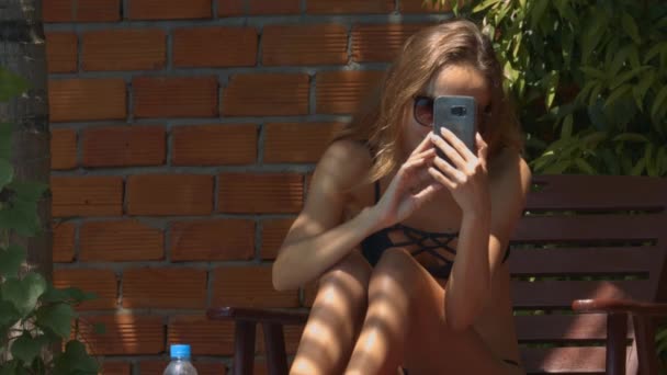 Close Menina Bronzeada Com Cabelos Longos Faz Vídeo Usando Smartphone — Vídeo de Stock