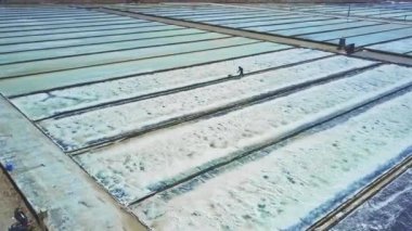 kürek üzerinde sınırsız tarlaları kristalize tuz toplama ile panoramik yerel adam İnşaat