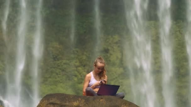 Sportovní Dívka Notebookem Smartphone Sedí Starých Cliff Velký Krásný Vodopád — Stock video