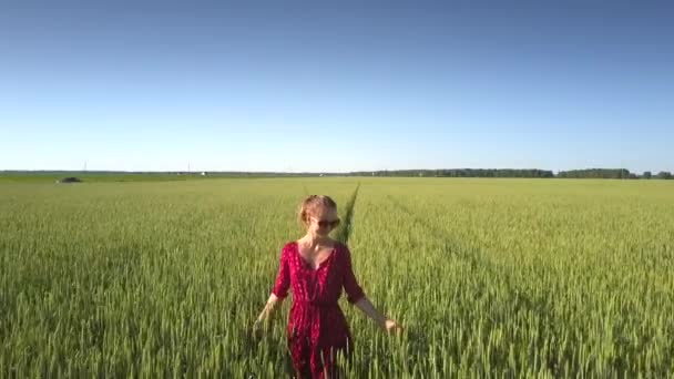 Flycam películas dama con vestido corto rojo y gafas de sol — Vídeo de stock