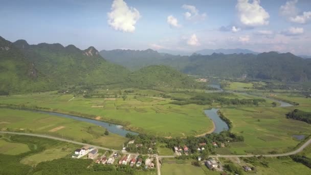 Город и дорога на изогнутой реке против гор воздушный вид — стоковое видео