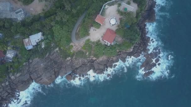 Sakin okyanusun yakınındaki sarp kayalıklarda, otelin üstünde kamera yükseliyor. — Stok video