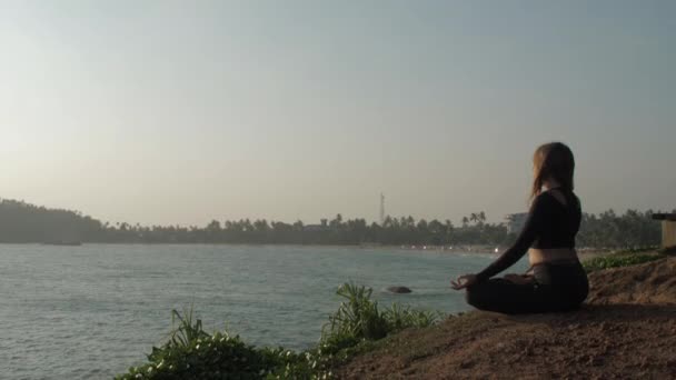 Eşofmanlı kadın yoga pozunda meditasyon yapıyor. — Stok video