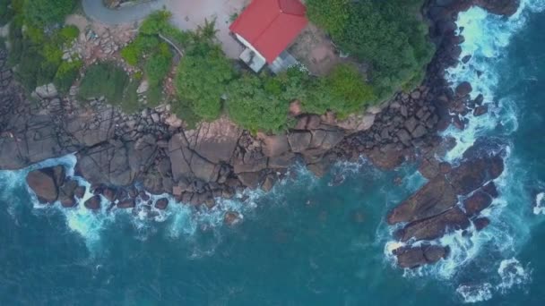 Kamera se zvedá nad chrám na strmém útesu poblíž klidného oceánu — Stock video
