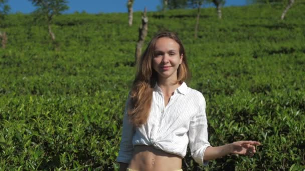 Счастливая девушка ходит среди чайных кустов на плантации замедленной съемки — стоковое видео